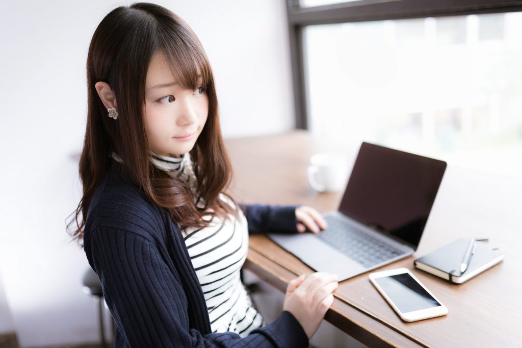 パソコンで何かを調べる女性