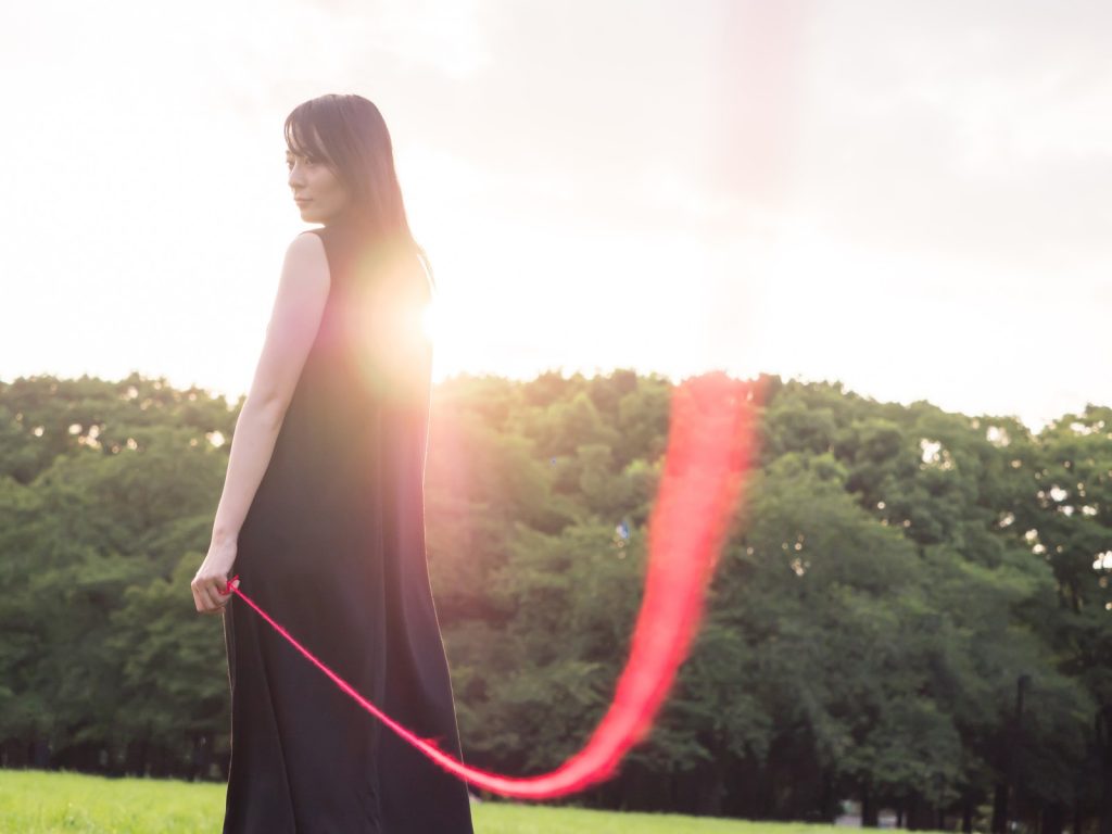 赤い糸でつながれた女性