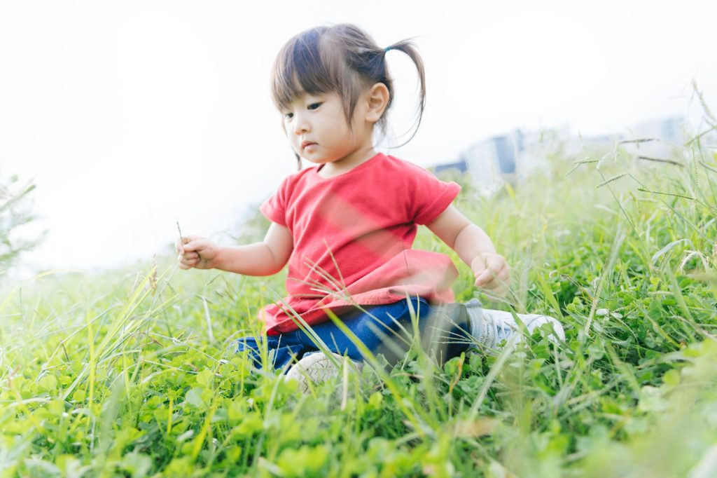 こども草むらで遊ぶ女の子