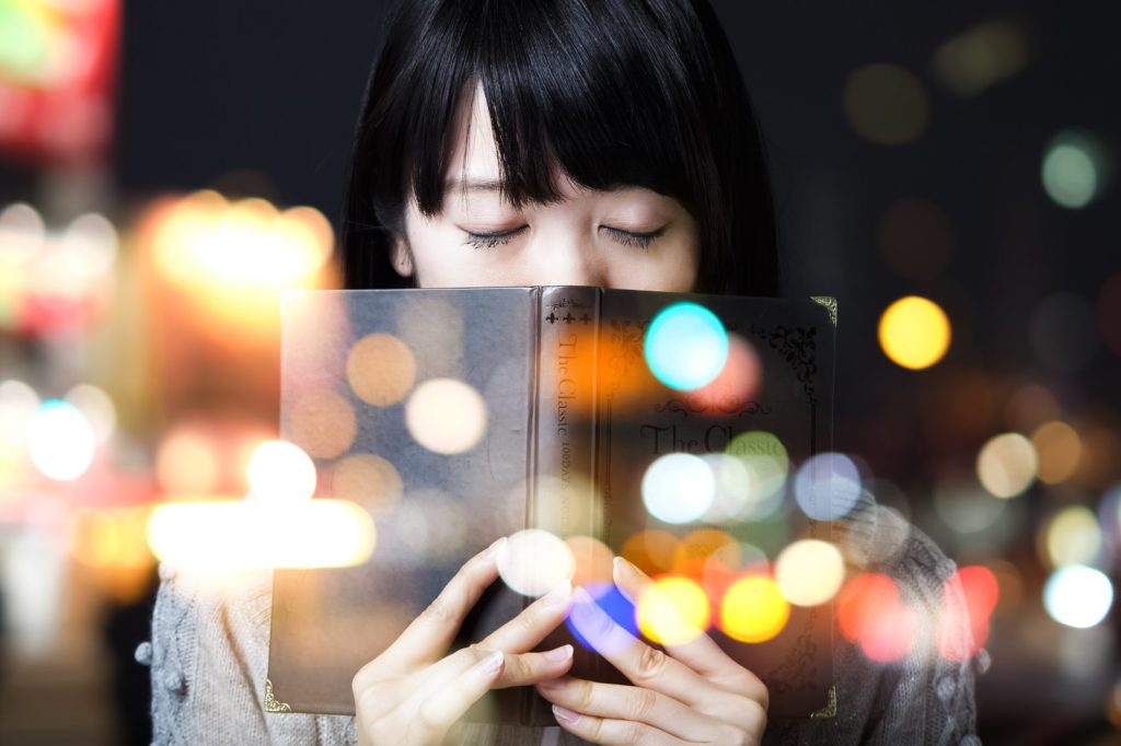 本を読み何かを思い出す女性