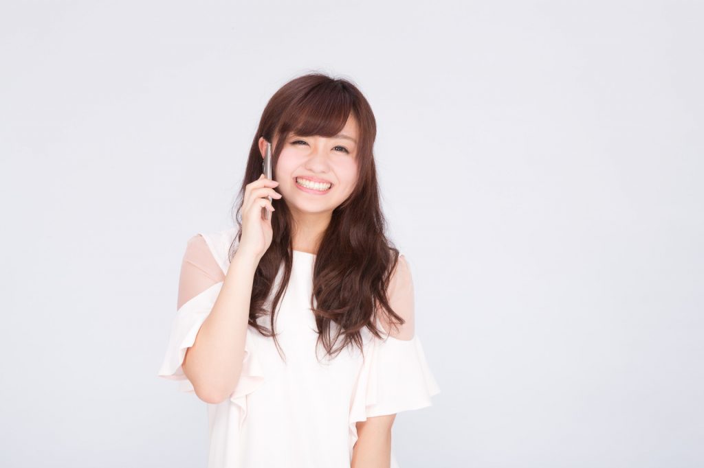 電話で笑顔がこぼれる女性